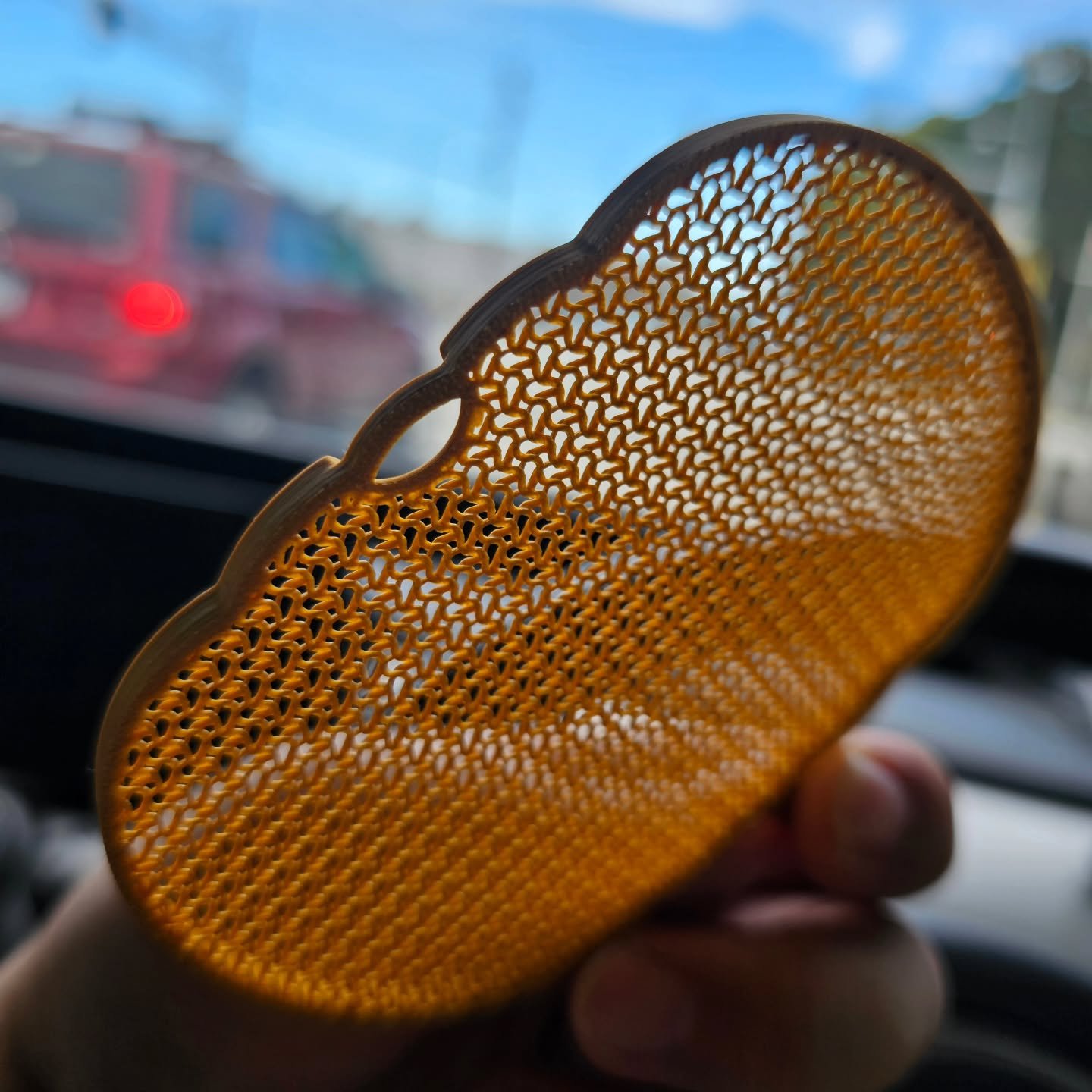 Open-mesh 3D-printed pumpkin held up to the light